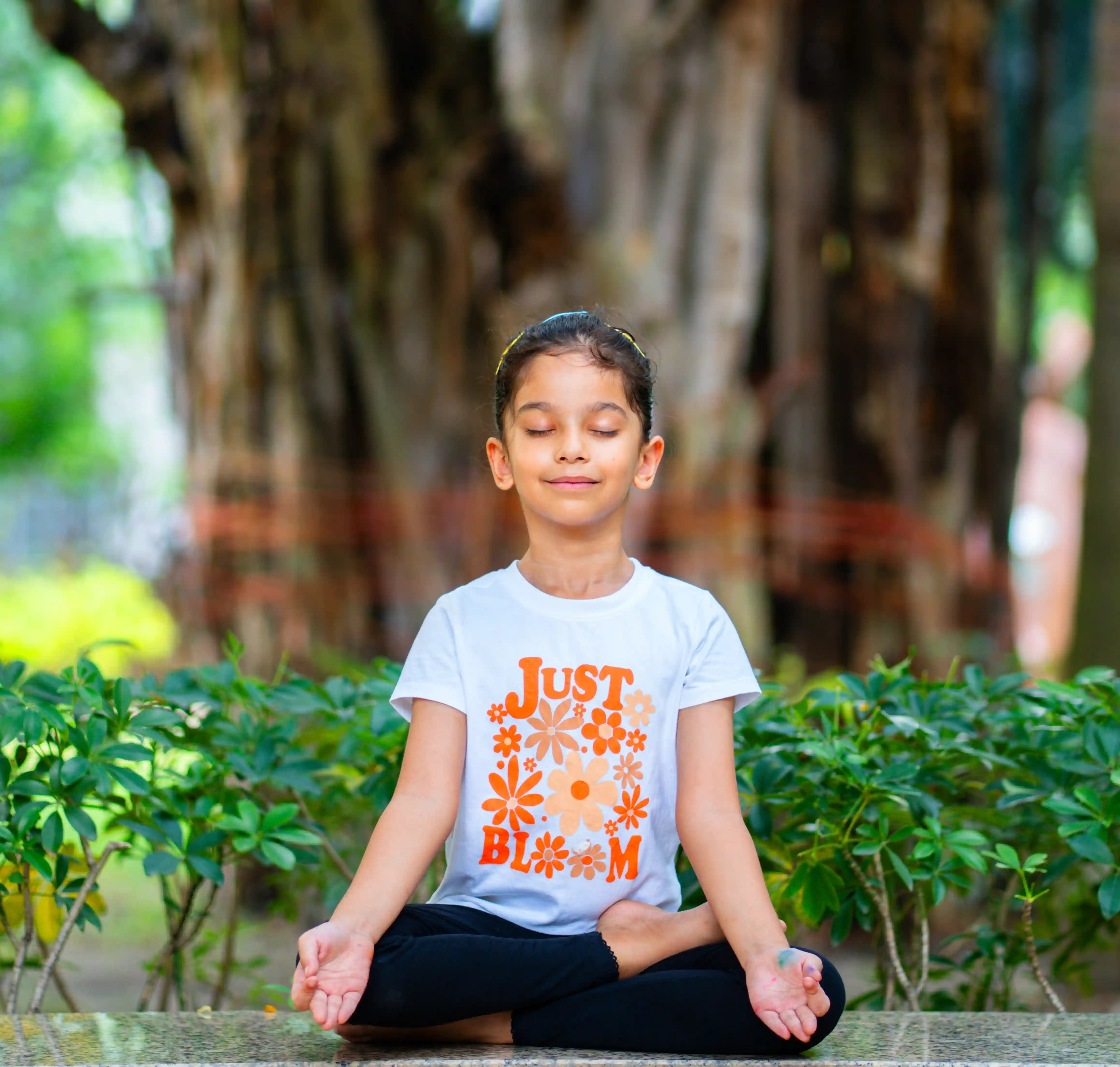 A peaceful child experiencing a deep spiritual awakening during an online yoga beginners course, beautifully guided by Gaurav Tribedi at Nabatara in a calming golden and maroon setting.